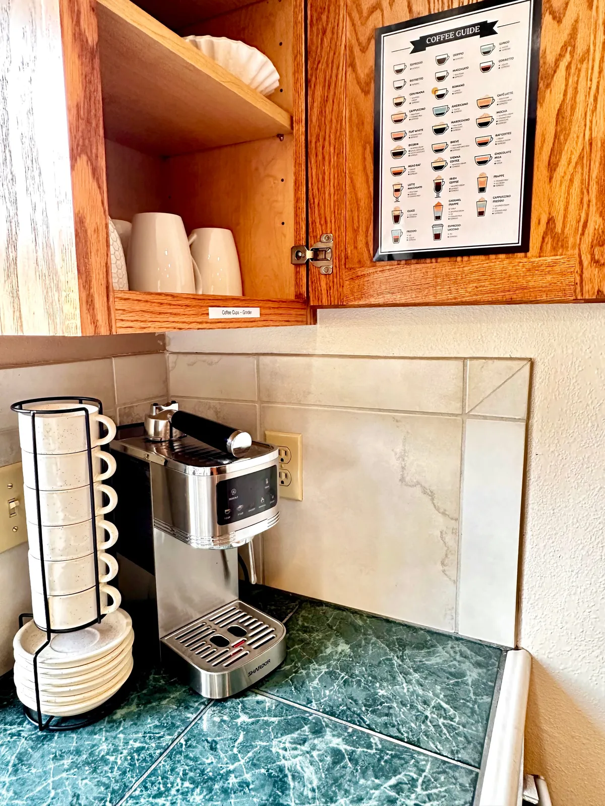 A welcoming kitchen nook featuring a modern coffee machine, ceramic mugs, and a curated coffee guide. Sunlight streams in, highlighting the inviting atmosphere, perfect for starting a morning before heading out for a walk.